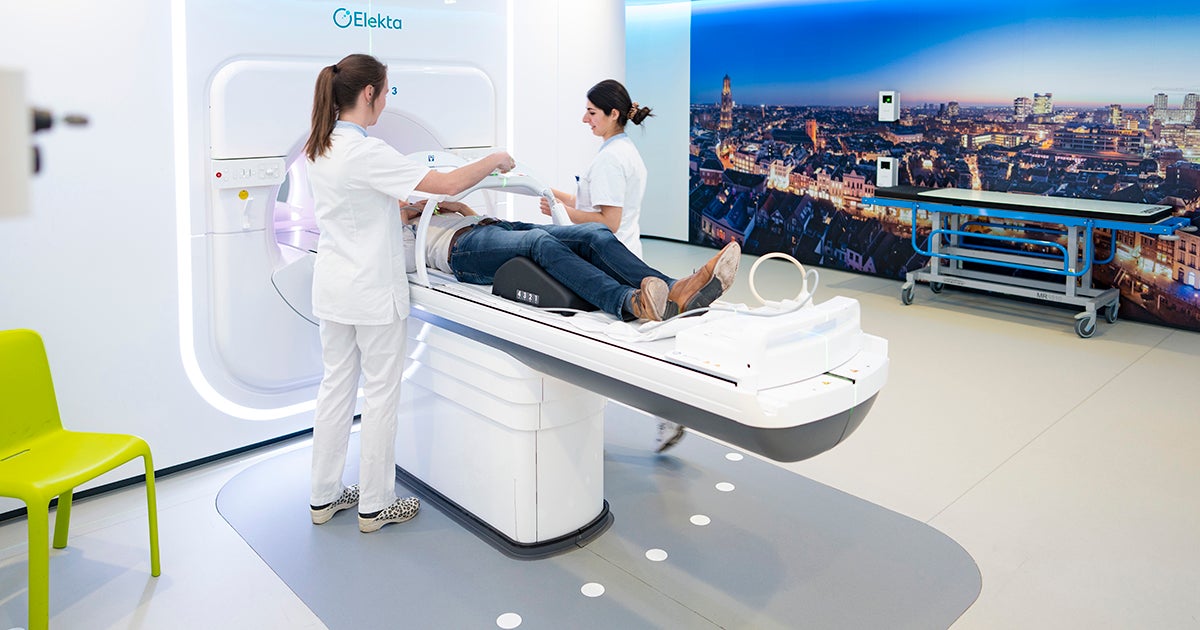 Patient in MR Linac machine, with two healthcare providers next to it.