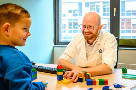 Zorgverlener en SMA patiënt Mick spelen met blokken