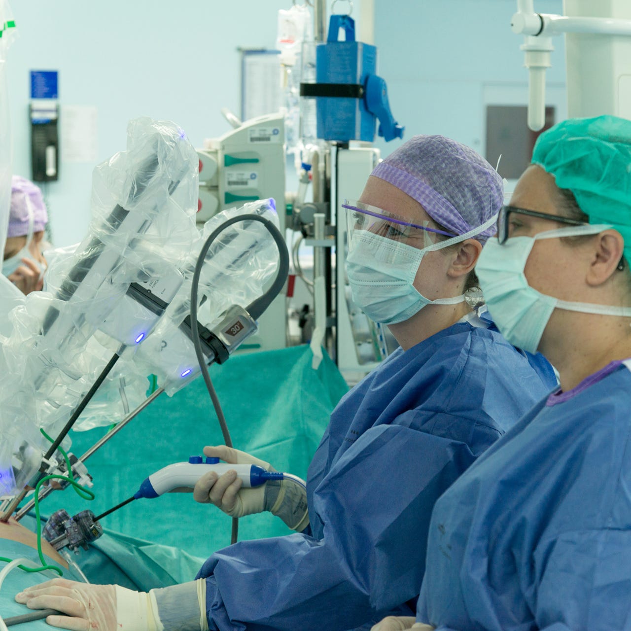 Twee chirurgen besturen een operatierobot.