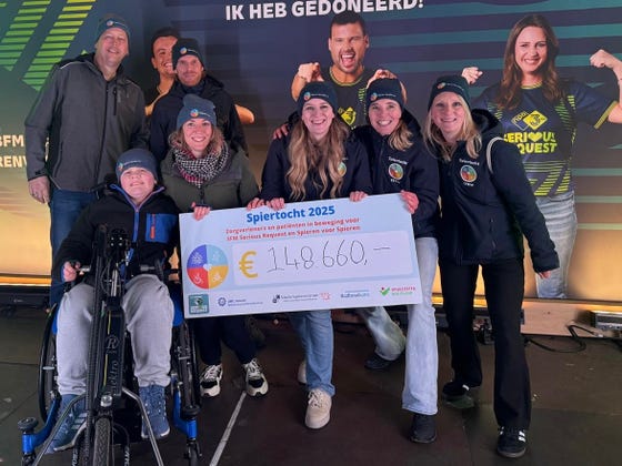 Een groep mensen poseert voor een foto met een cheque van de Spiertocht. Daarop staat € 148.660,-.