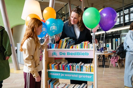 Een jonge patiënt in het WKZ kiest een boek uit de BedBieb.