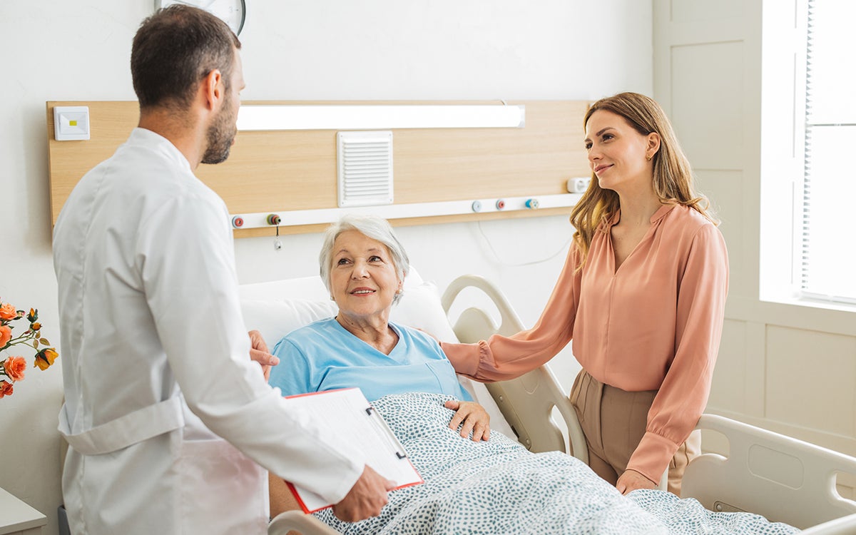 Arts naast het bed van oudere patiënt