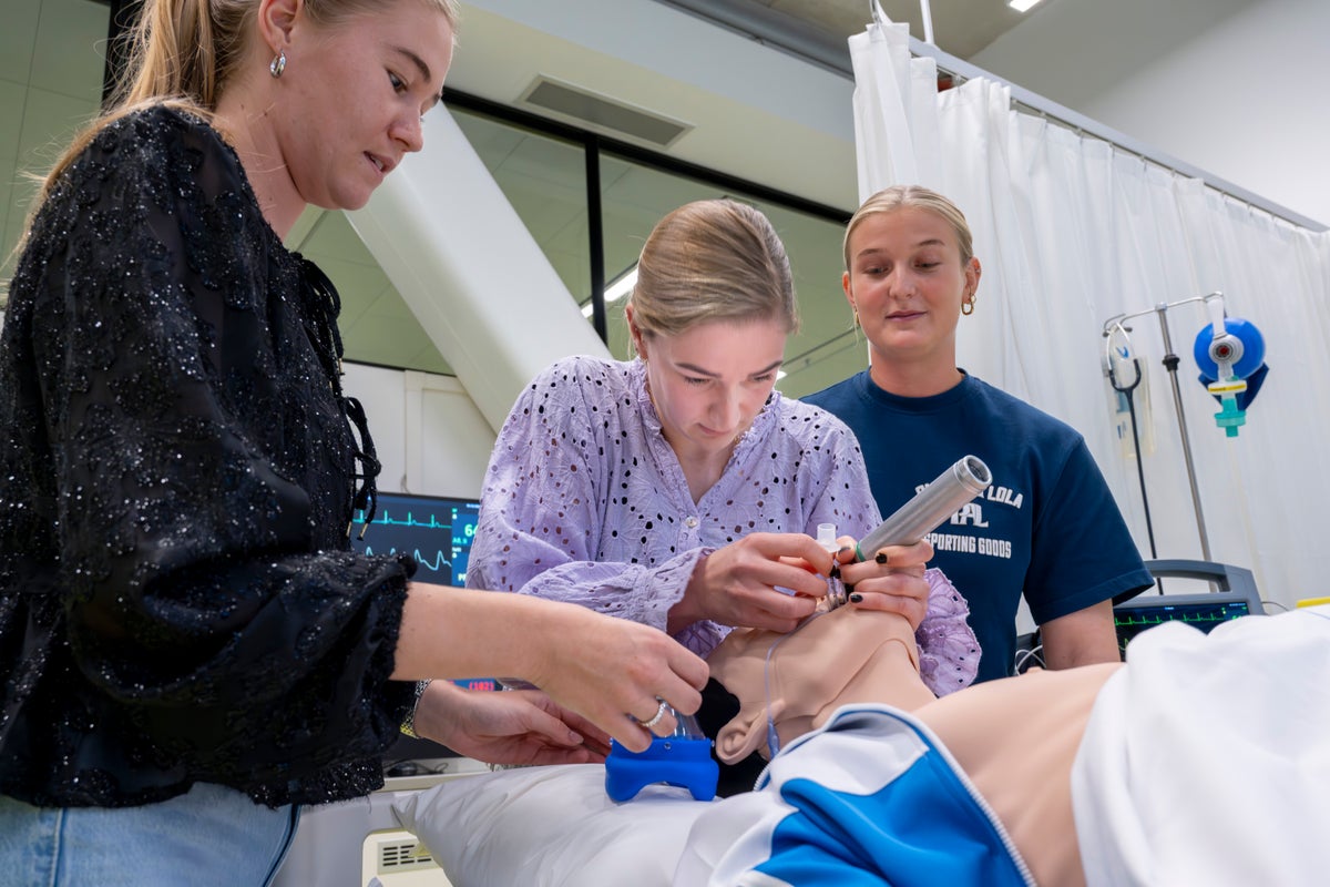 Een groep vrouwen werkt aan een oefenpop