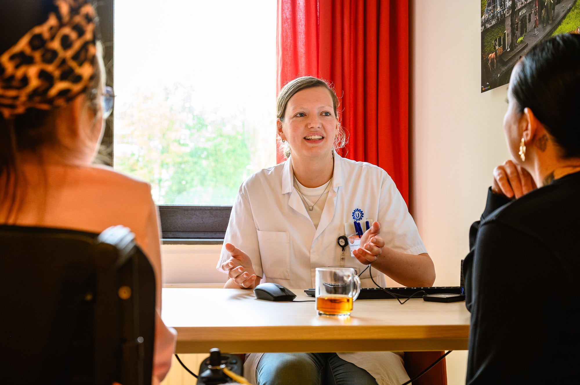 Irene Oude Lansink in een witte jas praat met twee vrouwen