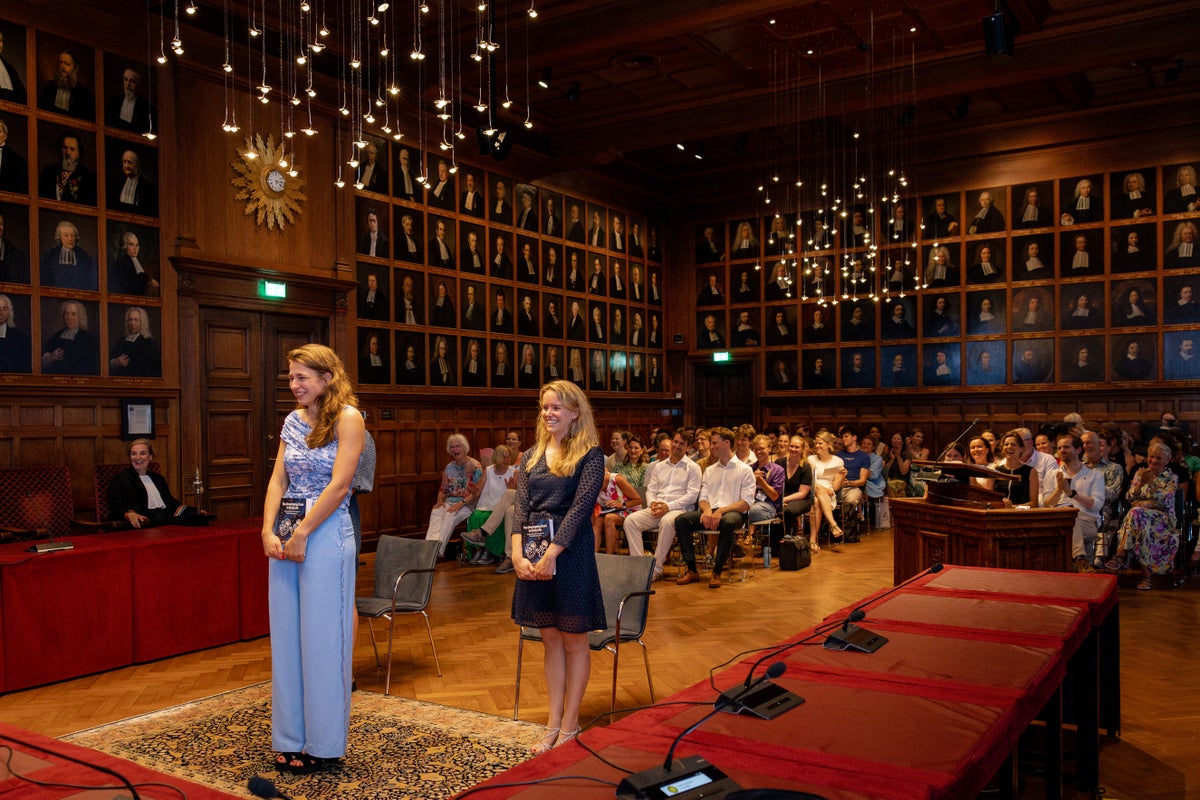 Twee vrouwen die op een podium staan voor een publiek