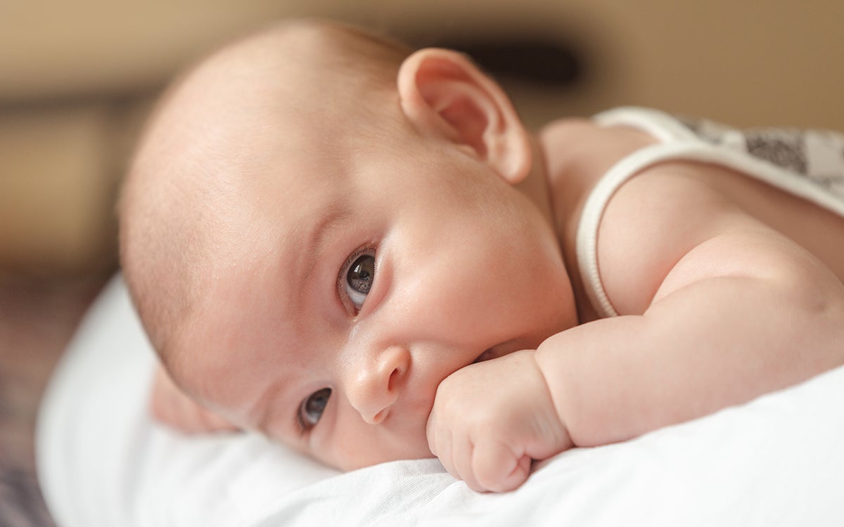 Een baby kijkt in de camera.