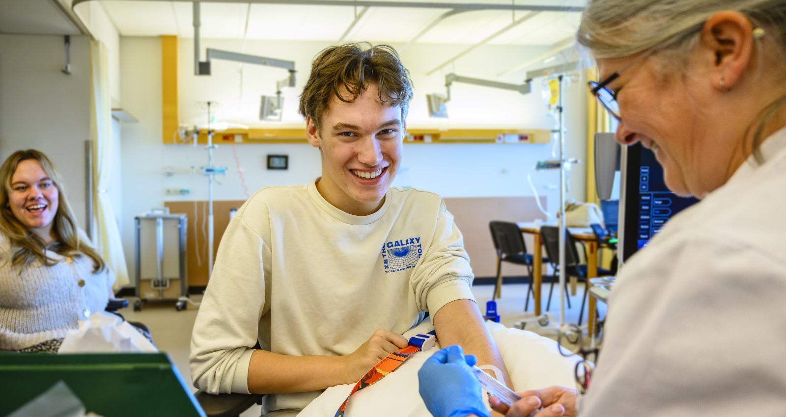 Een zorgverlener lacht naar een patiënt