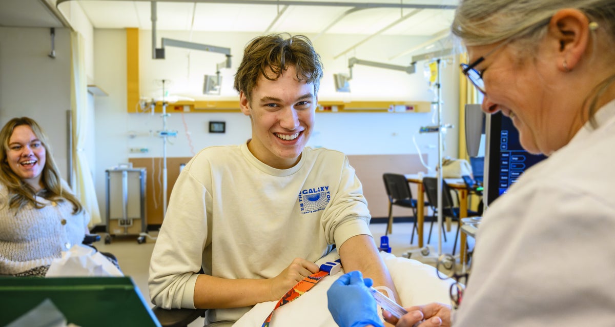 Een zorgverlener lacht naar een patiënt