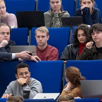 Marco van Brussel in een collegezaal met studenten.