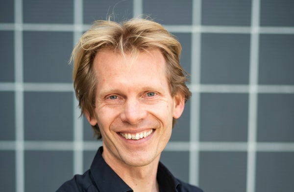 Een man lacht naar de camera