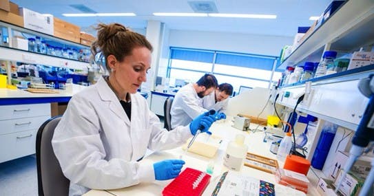 Een groep mensen in laboratoriumjassen die in een laboratorium werken