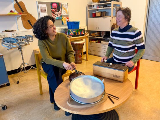 Twee vrouwen aan tafel spelen op muziekinstrumenten