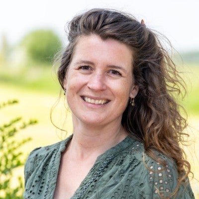 Een vrouw die naar de camera glimlacht