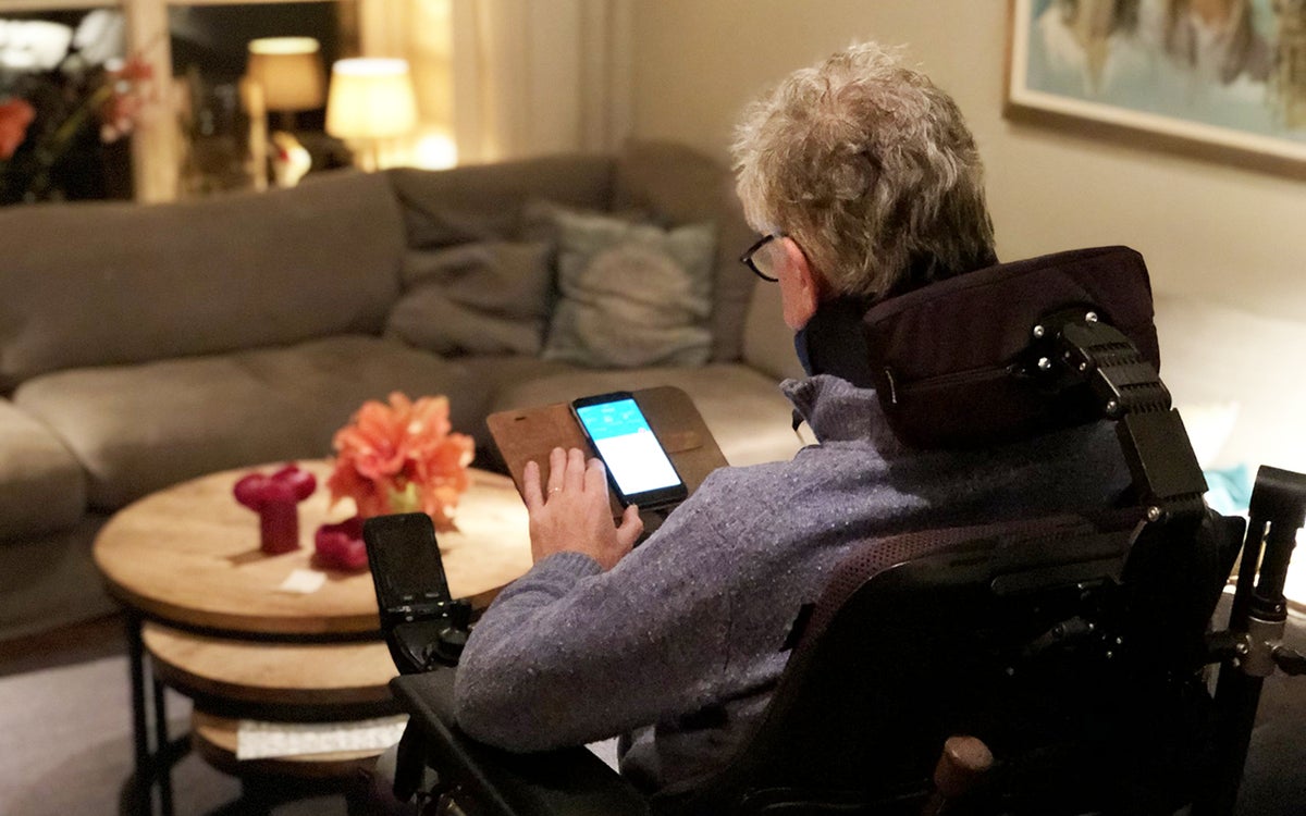 Patiënt in rolstoel gebruikt smartphone