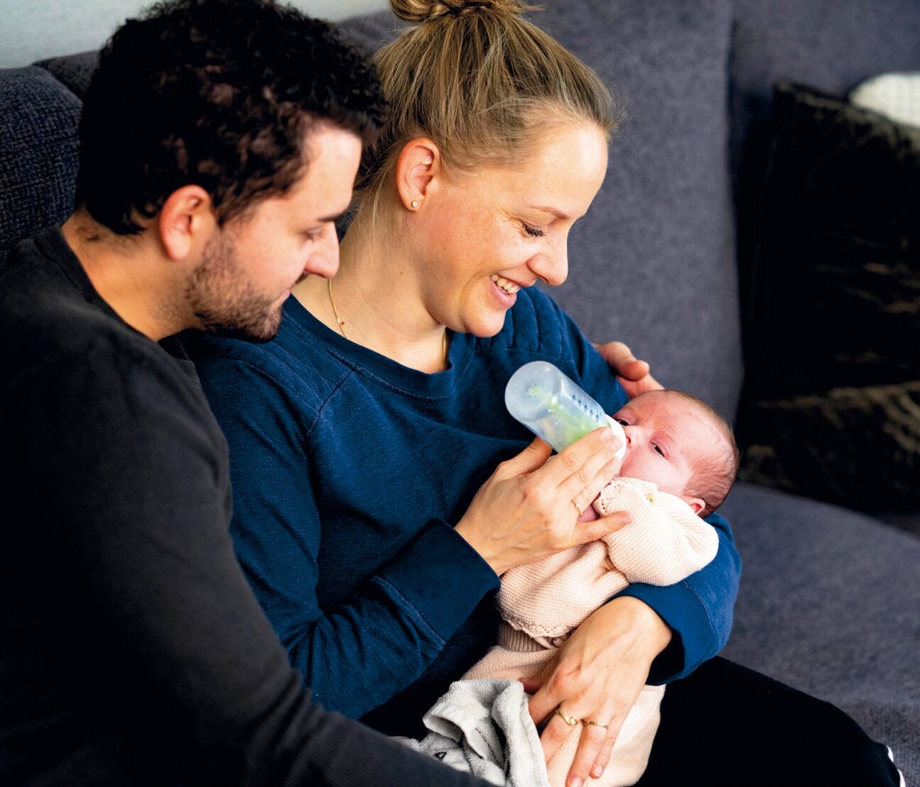 Man en vrouw met een baby die de fles krijgt
