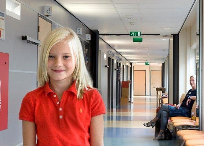 Een meisje in een rood shirt in een gang