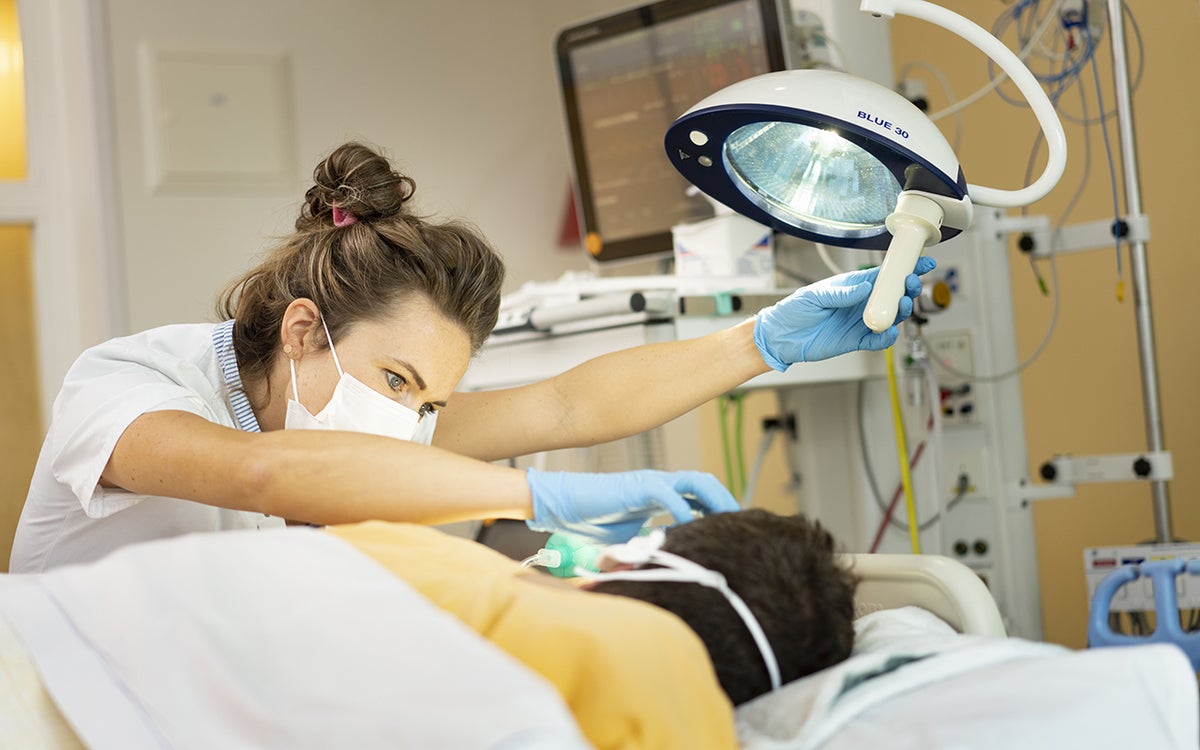 verpleegkundige aan IC bed bij patiënt