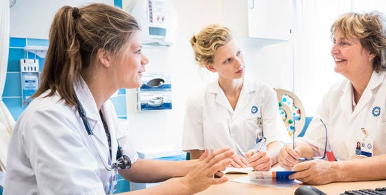 3 artsen in witte jassen zijn overleg (WKZ)